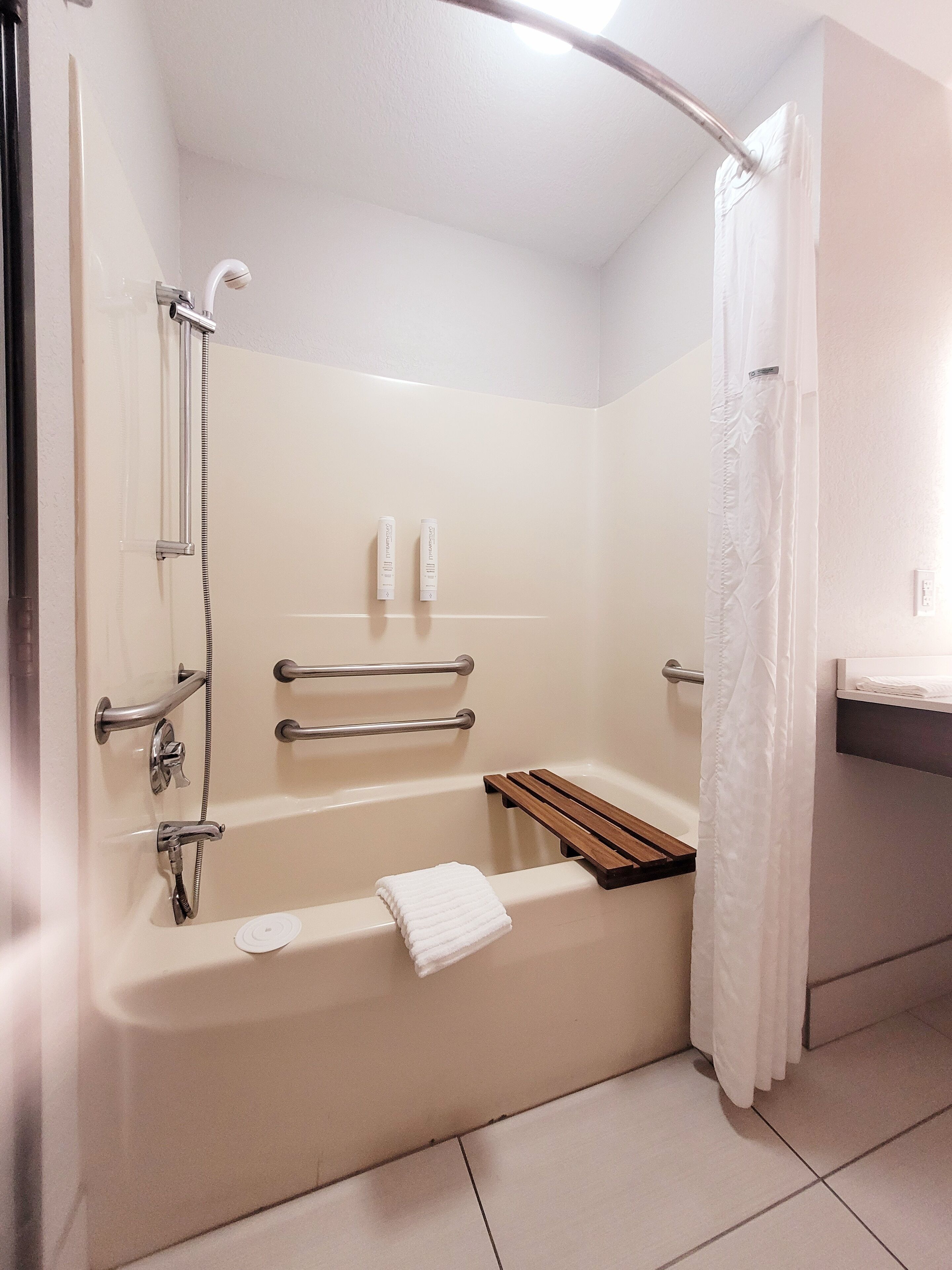 A modern bathroom with a bathtub, shower, and toilet.