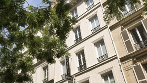 Un edificio de varios pisos con un cartel que indica que es un hotel.