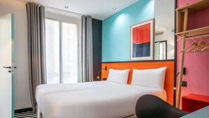 Una habitación de hotel con una cama grande, un escritorio, una silla, un armario y una ventana con cortinas.
