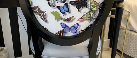 A chair with a circular backrest featuring a butterfly design.