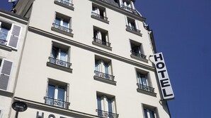 A multi-story building with balconies and a sign reading "HOTEL RIVIERA". - Hotel Riviera Elysées (Paris)