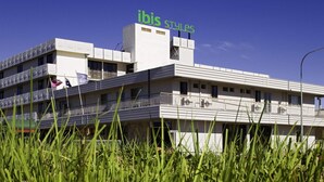 Un immeuble sur lequel on peut lire l’enseigne « ibis styles ». Il comporte plusieurs étages, avec des balcons et un toit plat.