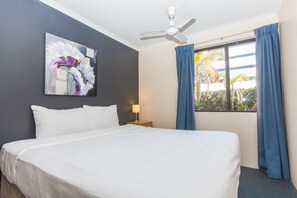 A hotel room with a bed, a ceiling fan, a window with curtains, and a painting on the wall. - Perth Central City Stay Apartment Hotel (West Perth)
