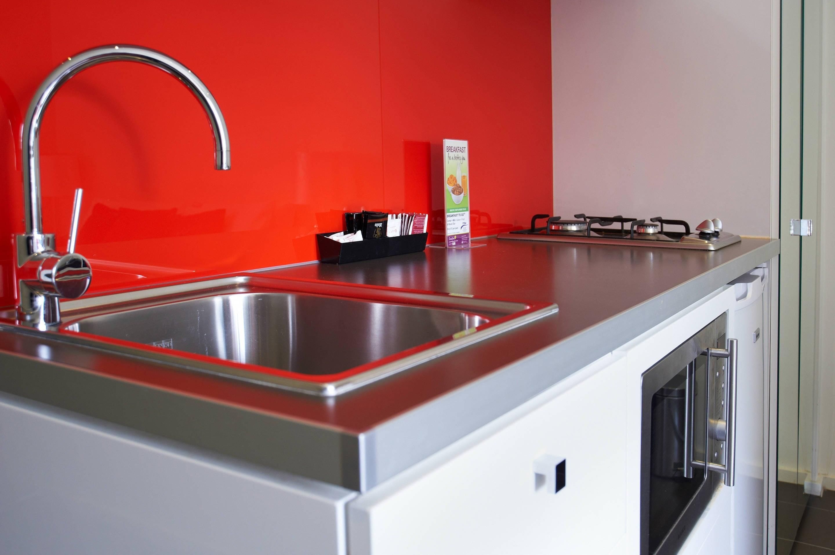 A kitchen with a stainless steel sink, a gas stove, and a breakfast sign.
