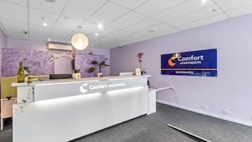 Un mostrador de recepción con un cartel de Comfort Apartments en Elizabeth.