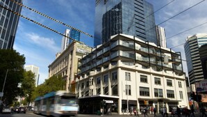 A multi-story building with a modern architectural style, featuring a mix of glass and concrete facades. - Comfort Apartments on Elizabeth (Melbourne)