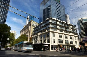 Un edificio de varios pisos con un estilo arquitectónico moderno, que combina fachadas de vidrio y concreto.