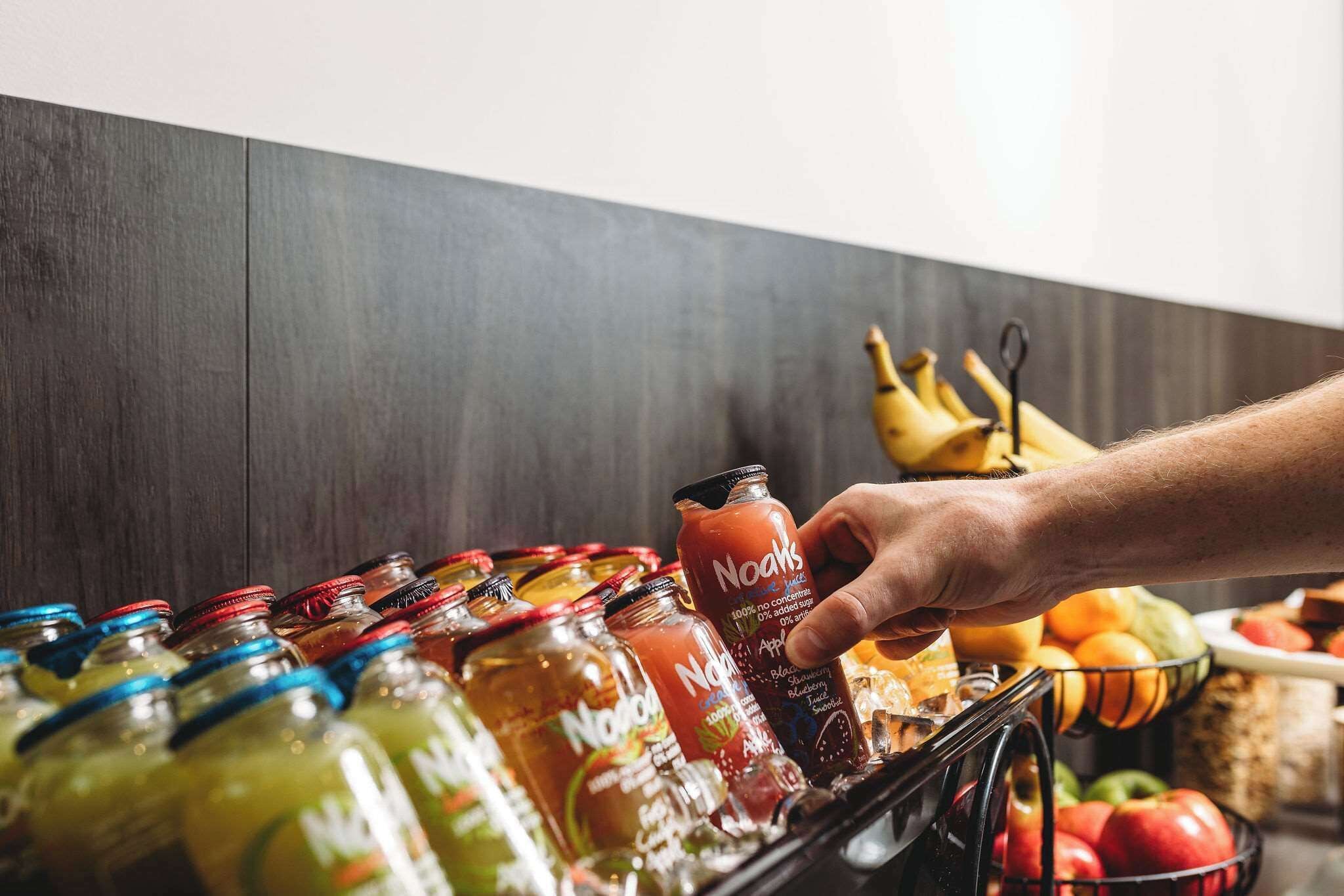 A hand reaching for a Nooaks drink from a selection of beverages.