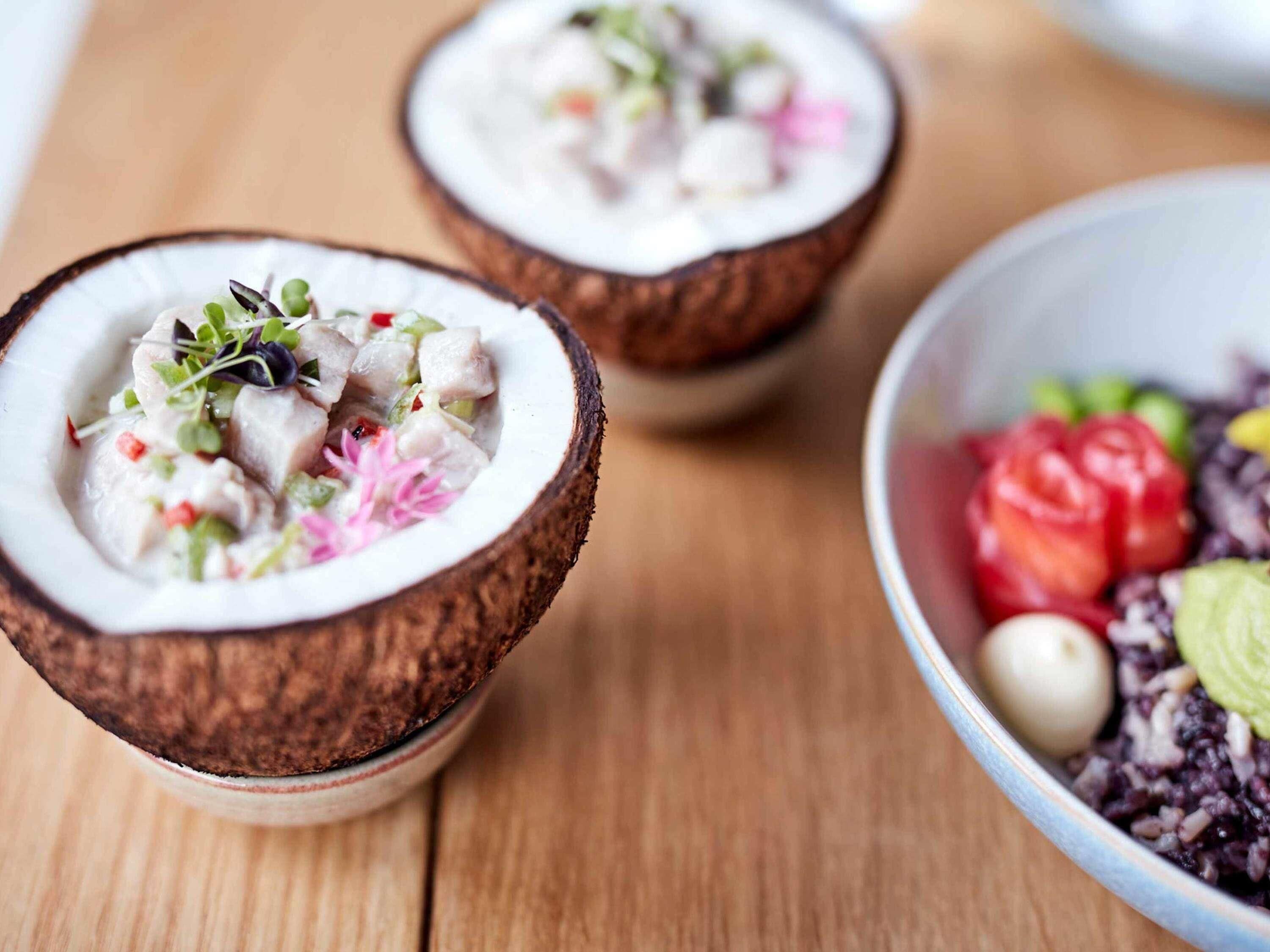 Two bowls of food with a wooden table.