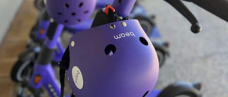 A purple electric scooter with a mounted camera and a helmet.