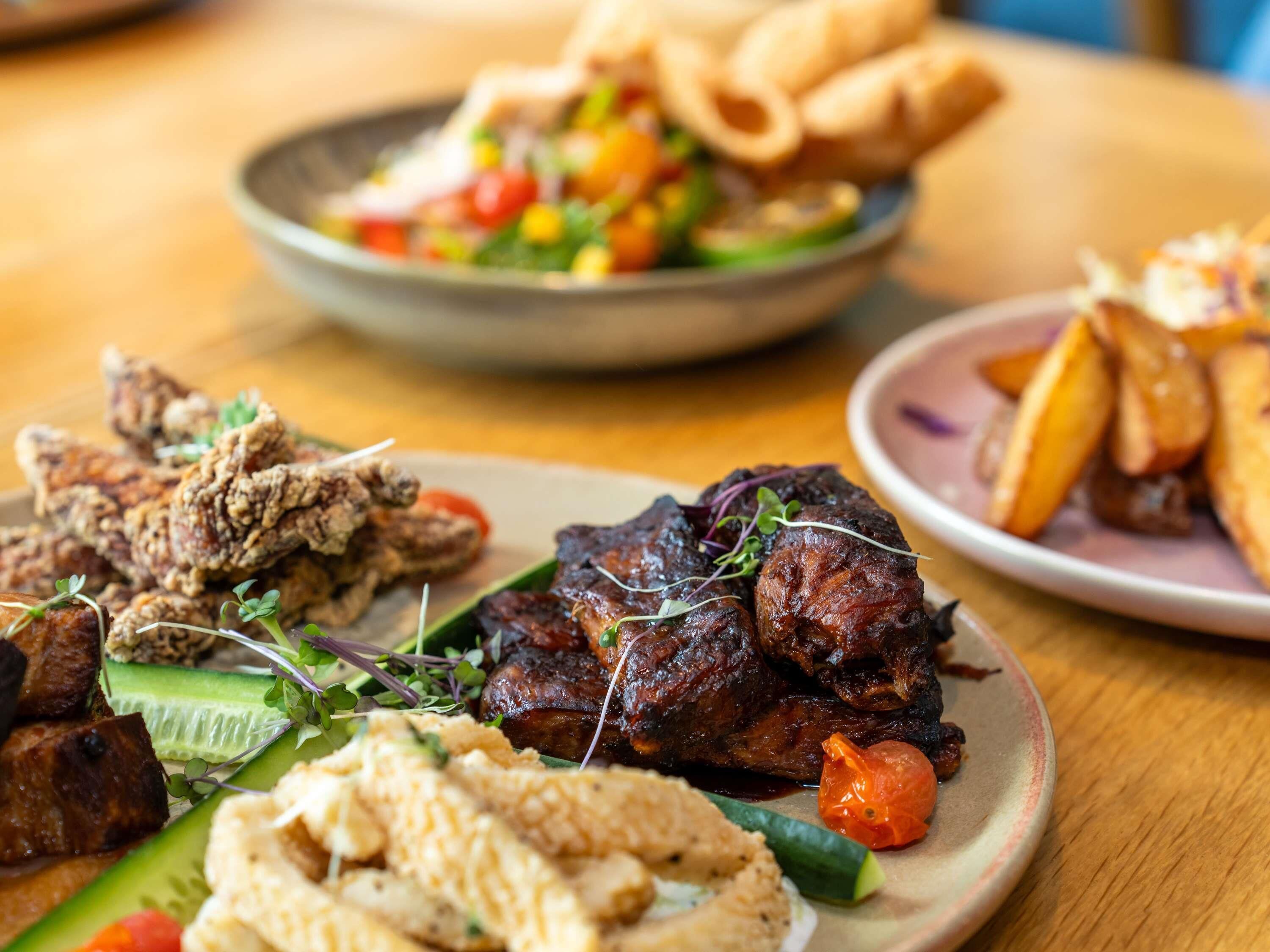 Un assortiment de plats comprenant du poulet frit, de la viande grillée et une salade.