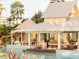 Una piscina al aire libre, sombrillas, sillones reclinables de piscina