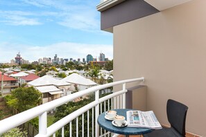 A balcony with a table, two cups of coffee, and a newspaper. - The Wellington Apartment Hotel (East Brisbane)