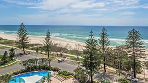 A beachfront property with a swimming pool, beach access, and a view of the ocean.