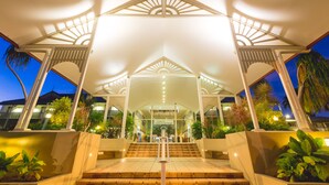 A hotel entrance with a covered walkway, steps leading up to the entrance, and surrounding greenery. - Cairns Colonial Club Resort (Manunda)