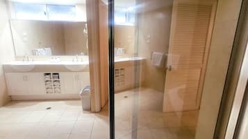 A bathroom with a large mirror, two sinks, and a glass shower enclosure.