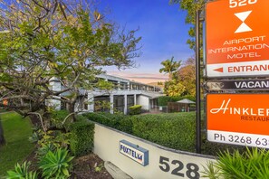 A sign for the Airport International Motel with a phone number and a restaurant nearby. - Airport International Hotel Brisbane (Hamilton)
