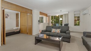 A modern living room with a sofa, a coffee table, and a sliding door closet.
