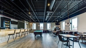 A spacious indoor area with a pool table, bar area, and seating arrangements. - Heritage Inn Hotel & Convention Centre Saskatoon (Saskatoon)