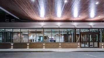 Un edificio moderno con techo de madera y amplios ventanales de vidrio.