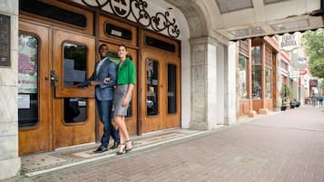 Une entrée d’immeuble avec une porte en bois et une enseigne au-dessus.