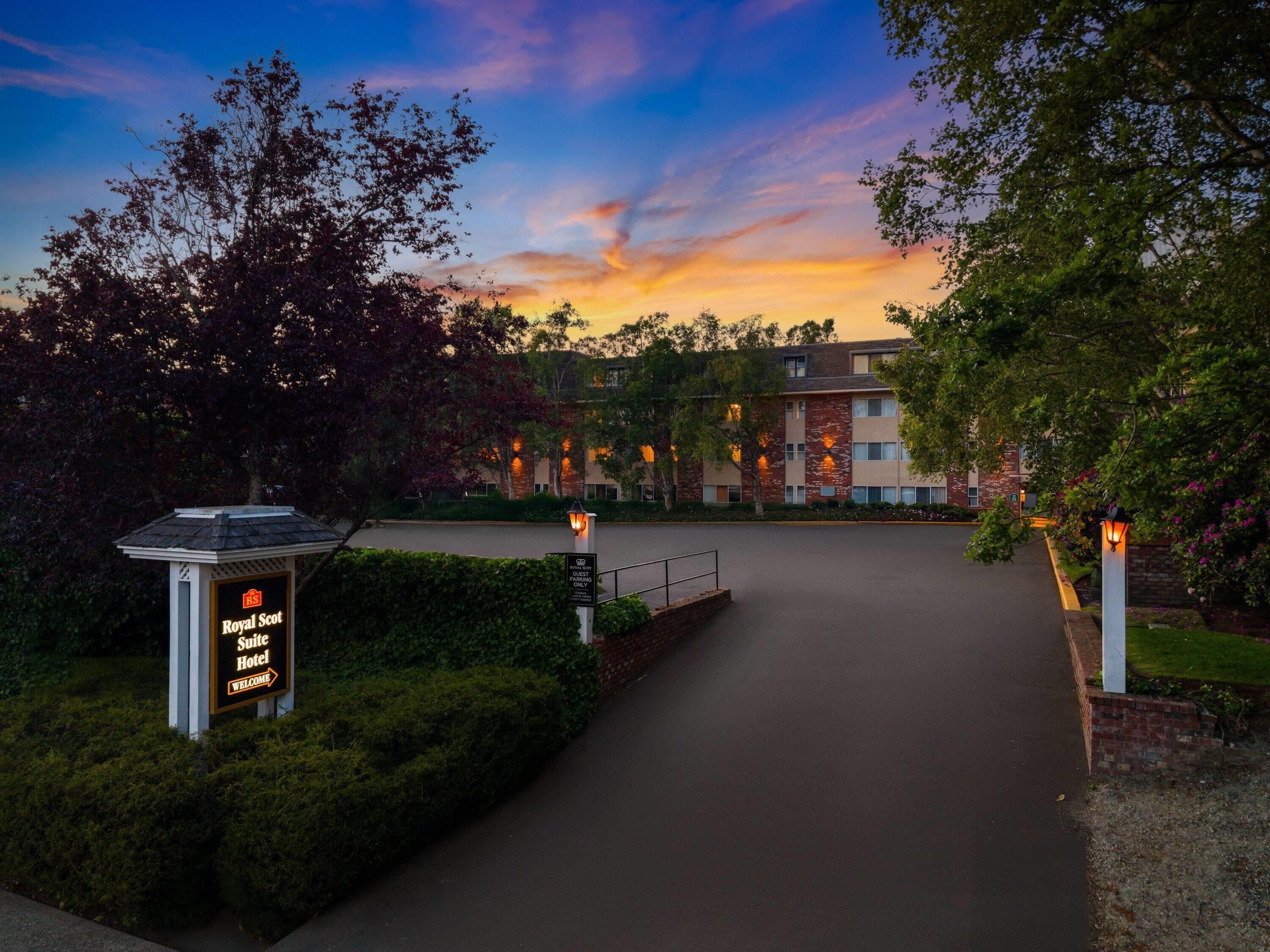 A hotel entrance with a sign for the Royal Scot Suite Hotel.