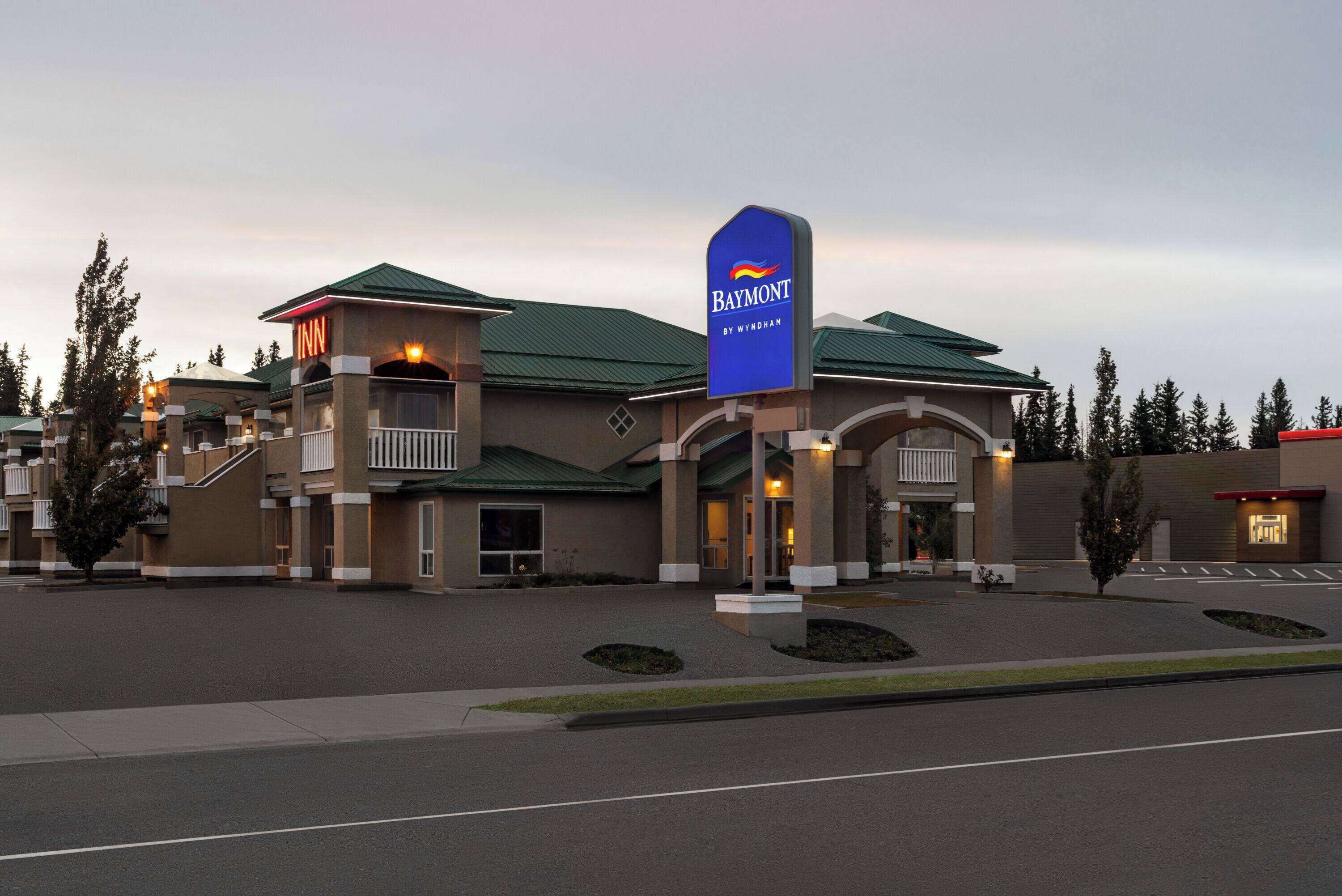 A Baymont Inn with a prominent blue sign, a covered entrance, and a landscaped driveway.