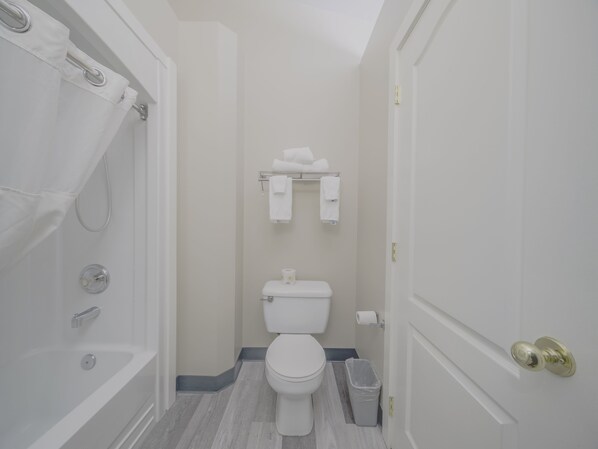 A small, clean bathroom with a shower, toilet, and towel rack.