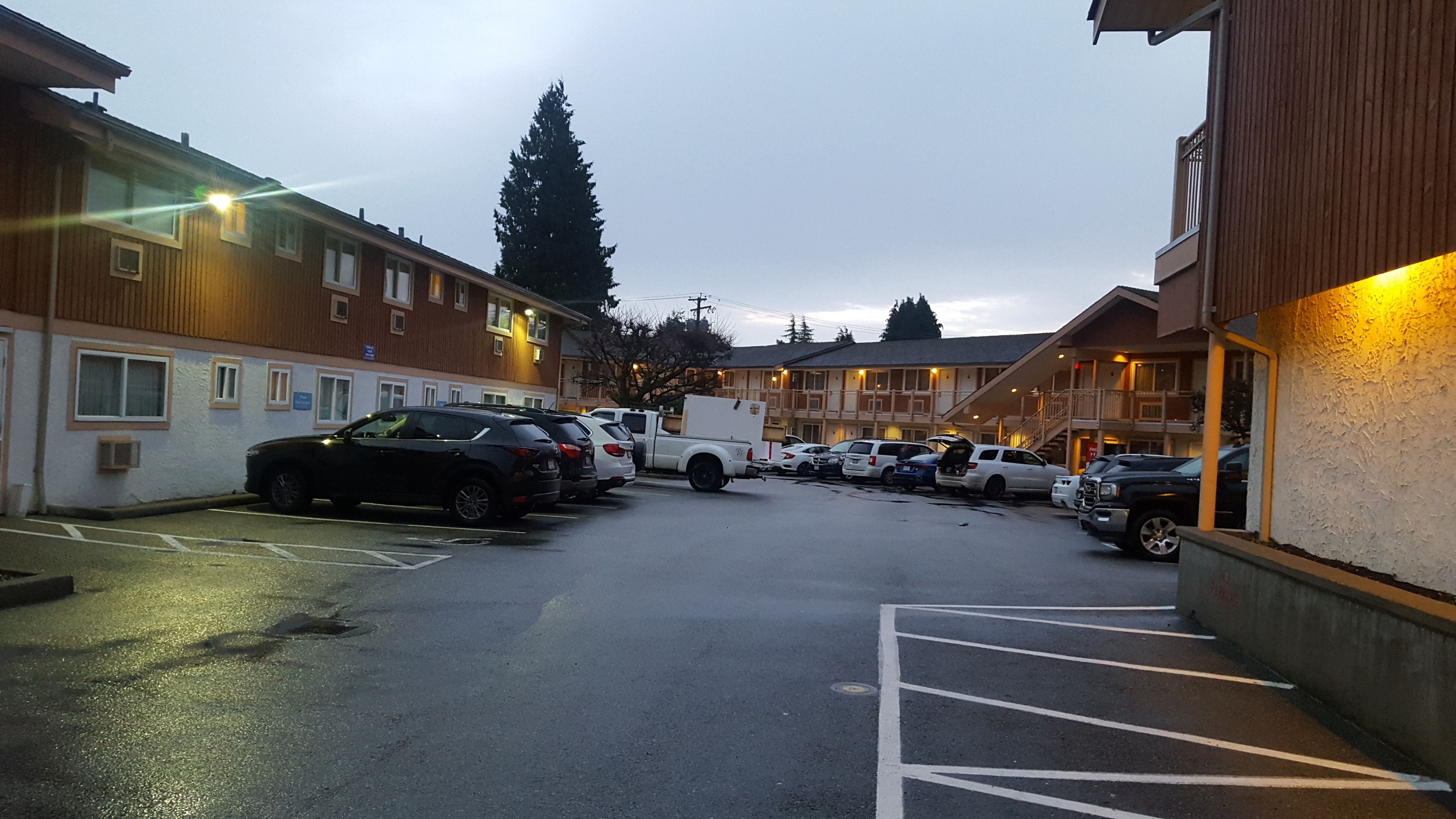A parking lot with several cars and a white truck.