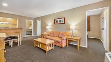 Ein Hotelzimmer mit Küchenzeile, einer Couch, einem Couchtisch und zwei Nachttischlampen.