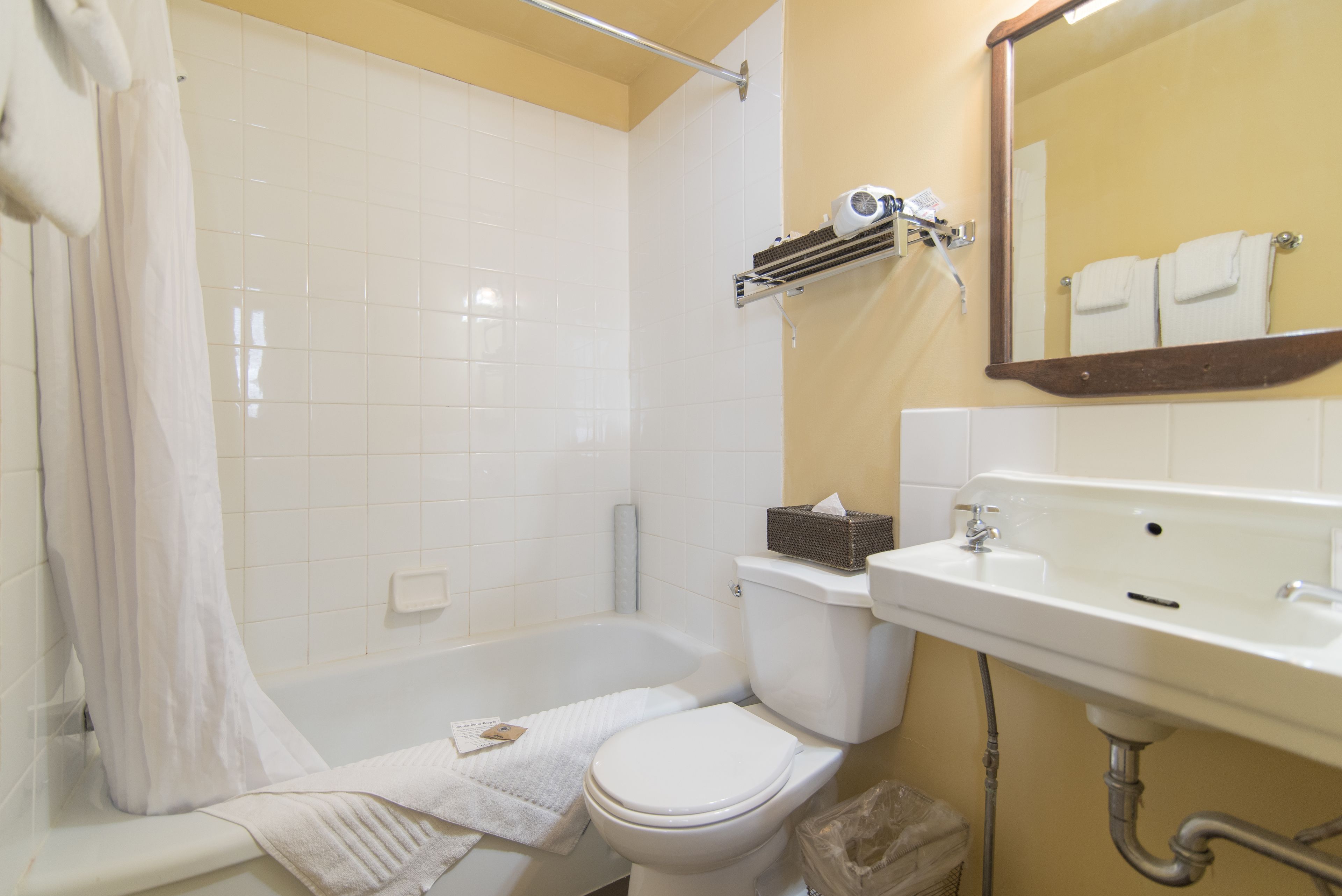 A bathroom with a bathtub, toilet, and sink.