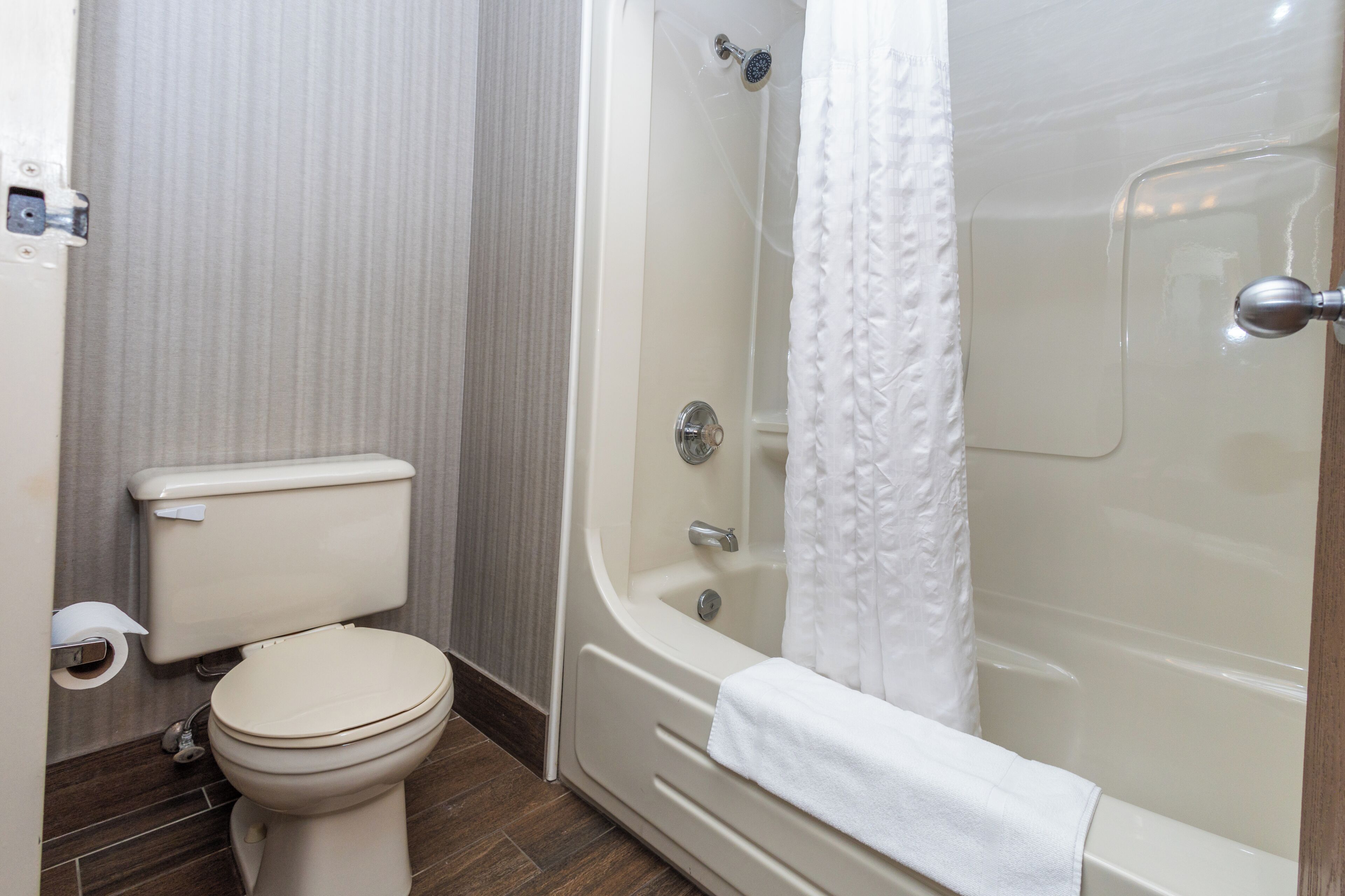 Un baño con inodoro, bañera y cortina de ducha.