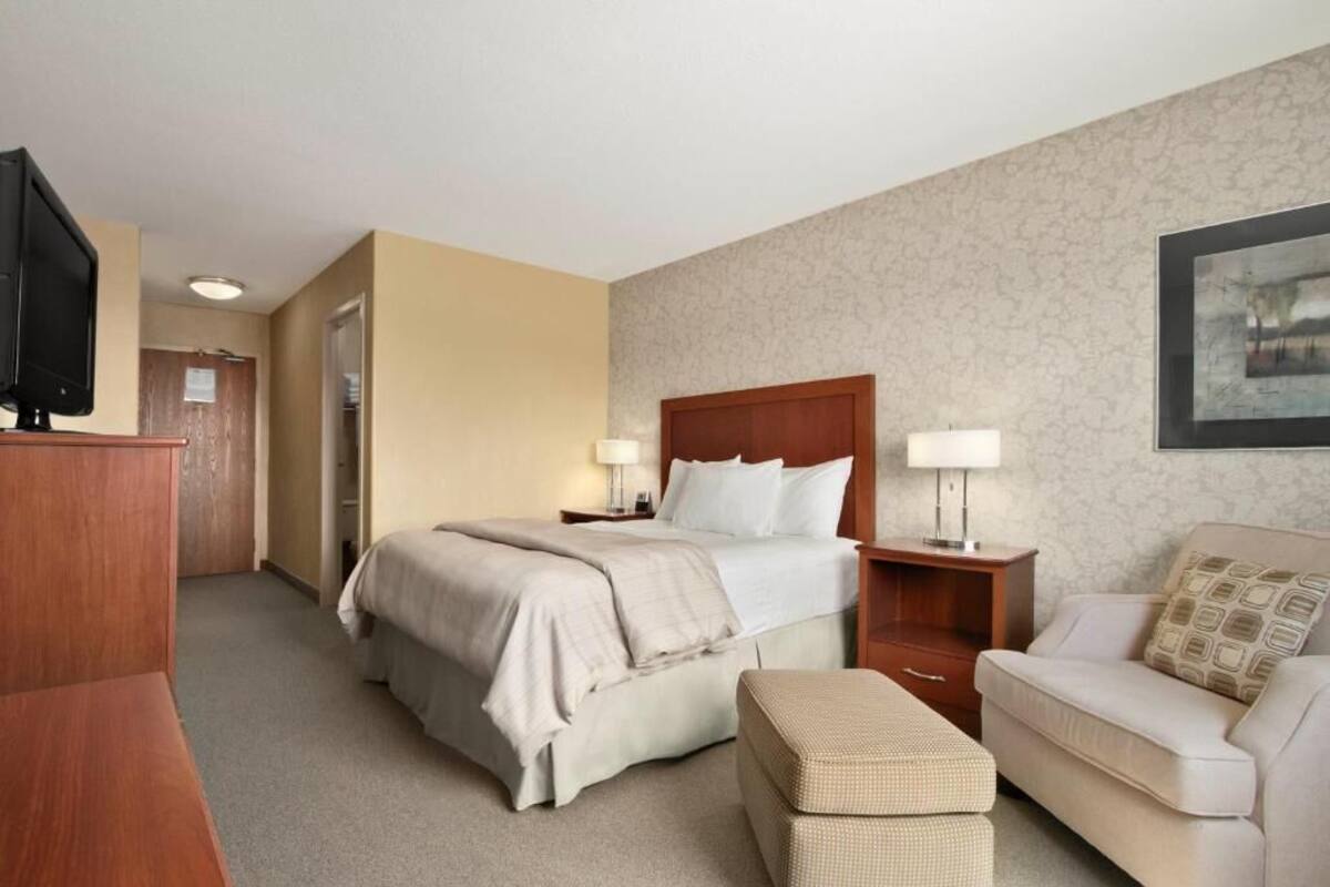 Une chambre d’hôtel équipée d’un lit, d’un bureau, d’une chaise et d’un téléviseur.