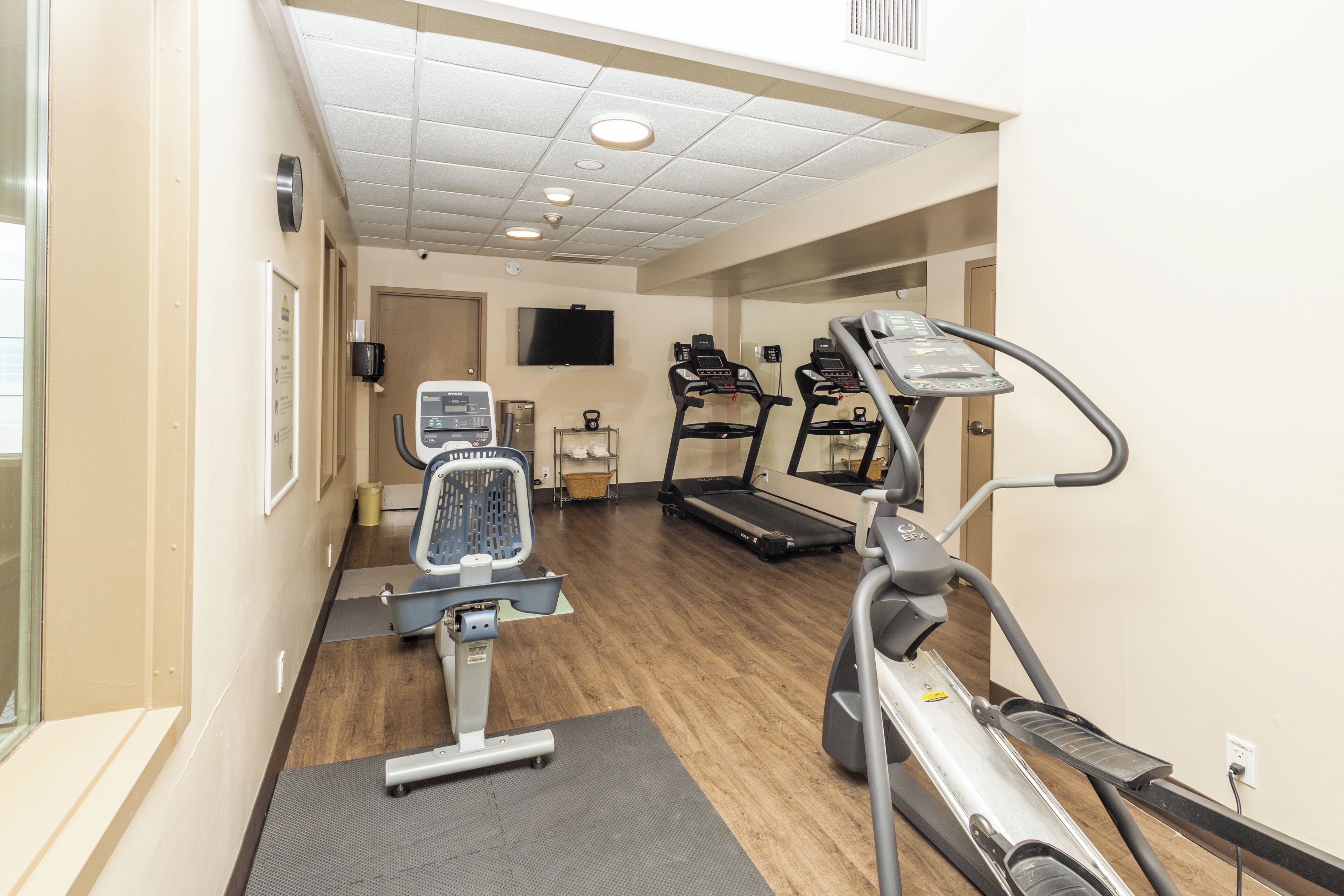A gym with treadmills, an elliptical, and a stationary bike.