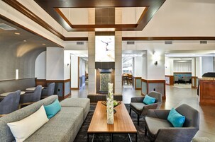 Un'ampia hall con un camino centrale, zone relax e vista sulla sala da pranzo.
