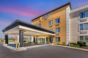 Um hotel Comfort Inn com entrada desobstruída, área de estacionamento coberta e fachada bem cuidada.