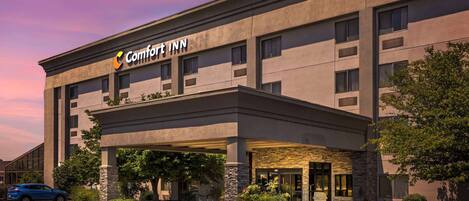 Un hotel Comfort Inn con fachada moderna, entrada cubierta y estacionamiento.