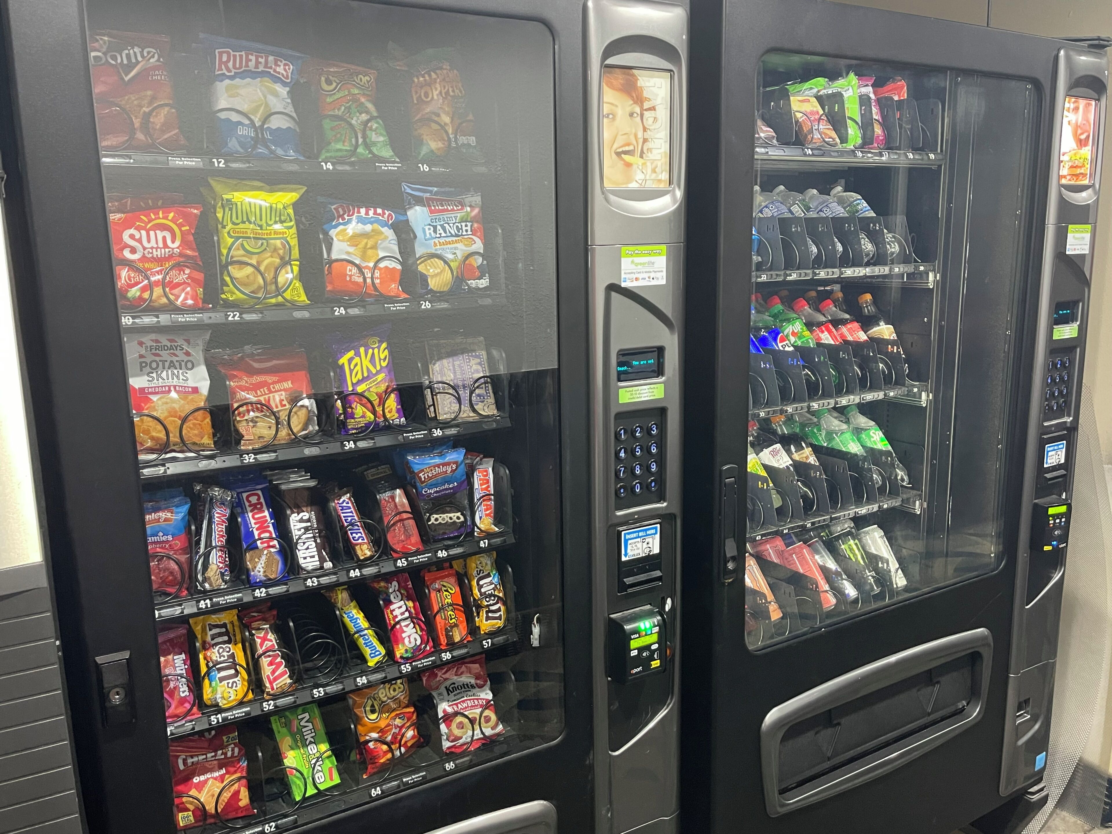Two vending machines stocked with snacks and beverages.