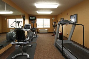 Un gimnasio con cintas de correr, elípticas y máquinas de pesas.