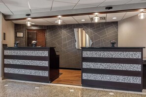 A reception area with two counters, a wooden floor, and a geometric wall design. - Drury Inn & Suites Atlanta Airport (Atlanta)
