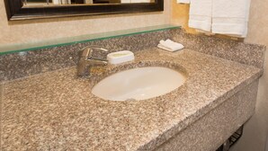 A granite bathroom sink with a mirror above it, a towel rack with two white towels, and a soap dish. - Drury Inn & Suites Atlanta Airport (Atlanta)