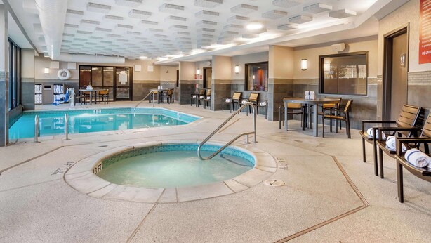 An indoor swimming pool with a hot tub, seating areas, and a ceiling with recessed lighting. - Drury Inn & Suites Atlanta Airport (Atlanta)