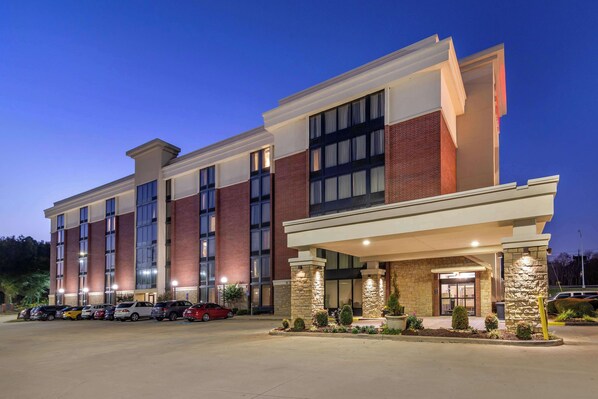 Stylish hotel with a symmetrical facade, large windows, and a welcoming entrance.
