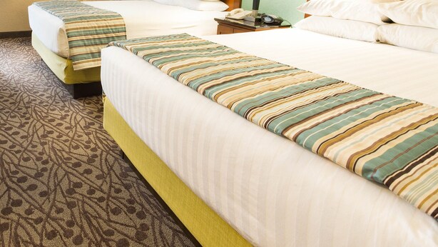 A hotel room with two beds, a nightstand with a lamp, a telephone, and a clock. - Drury Inn & Suites Atlanta Airport (Atlanta)