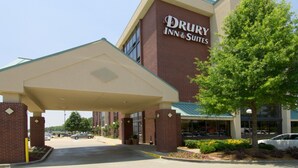 A Drury Inn & Suites building with a covered entrance, parking lot, and a tree in front. - Drury Inn & Suites Atlanta Airport (Atlanta)