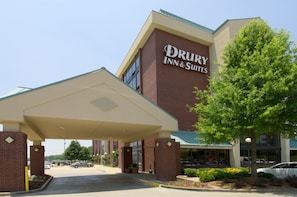 A Drury Inn & Suites building with a covered entrance, parking lot, and a tree in front. - Drury Inn & Suites Atlanta Airport (Atlanta)