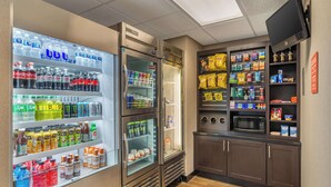 A kitchenette with a refrigerator stocked with beverages, a microwave, and various snacks. - Drury Inn & Suites Atlanta Airport (Atlanta)