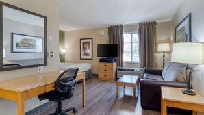 A hotel room with a bed, desk, chair, TV, couch, and lamp. - Extended Stay America Suites Pleasanton Chabot Dr (Pleasanton)