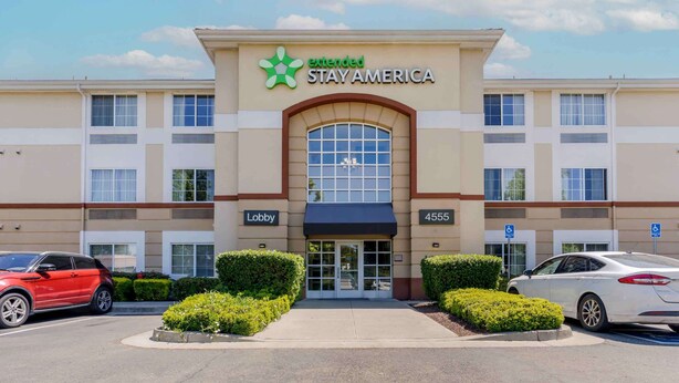 An extended stay America hotel with a lobby entrance, parking spaces, and a clear sky. - Extended Stay America Suites Pleasanton Chabot Dr (Pleasanton)