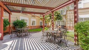 An outdoor patio with a pergola, tables, and chairs. - Extended Stay America Suites Pleasanton Chabot Dr (Pleasanton)